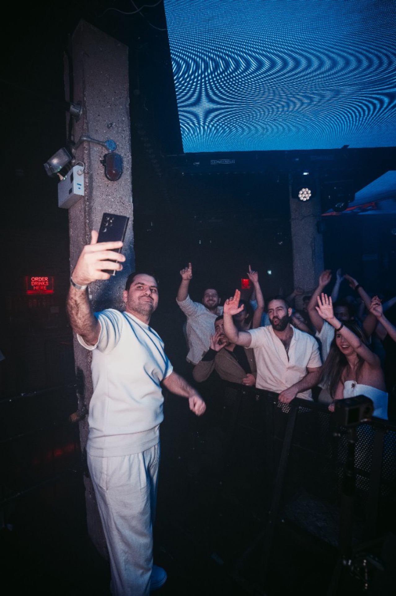 DJ Cincinati London performance with red neon Cincinati signage and club lighting