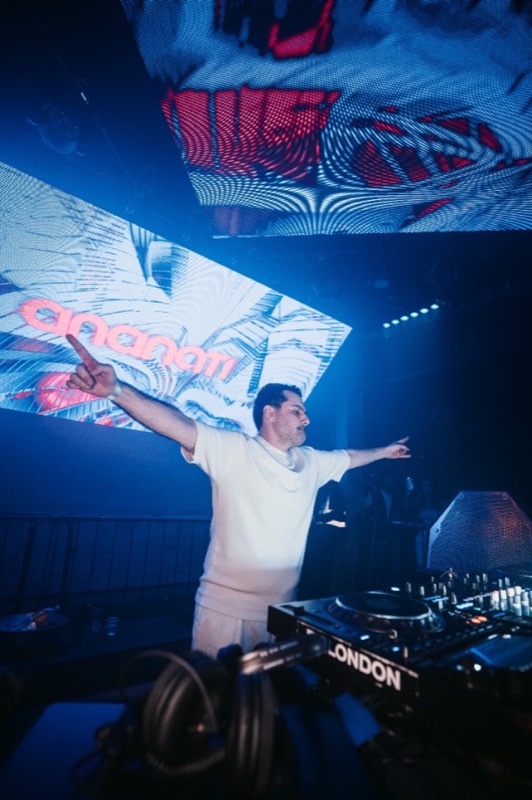 Live Persian DJ set in London — blue and red LED visuals behind the DJ booth